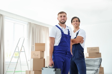 Portrait of male movers in uniform indoors