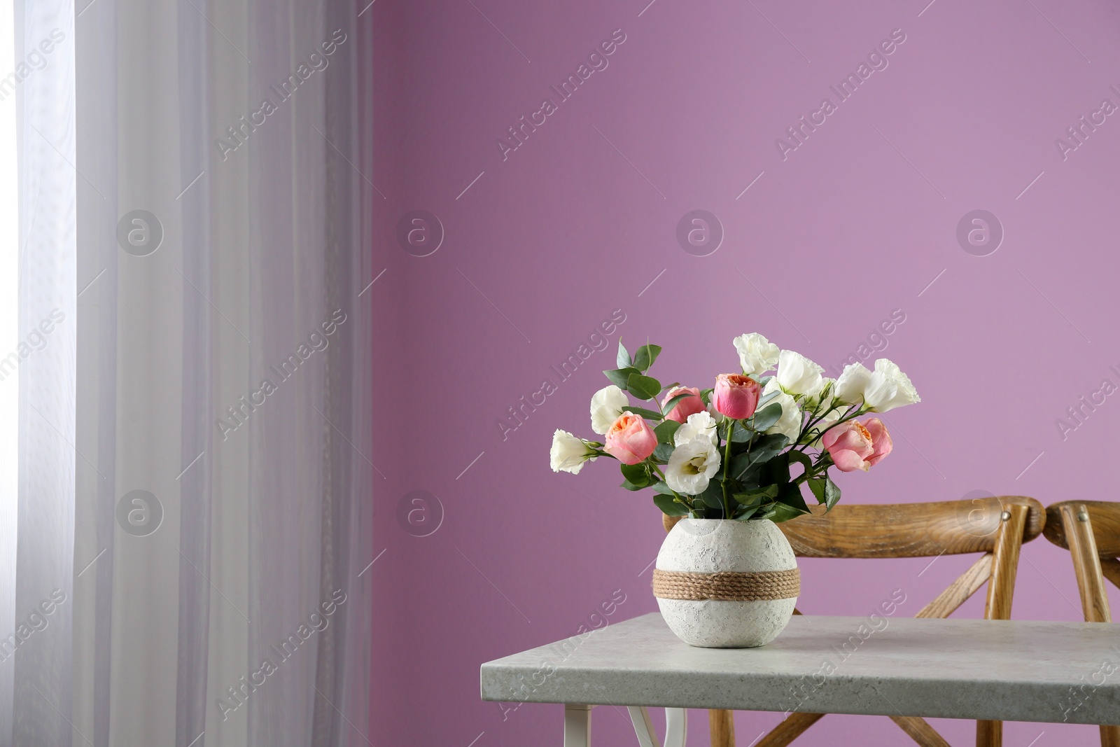 Photo of Vase with beautiful flowers as element of interior design on table in room. Space for text