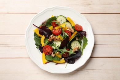 Photo of Tasty fresh vegetarian salad on light wooden table, top view