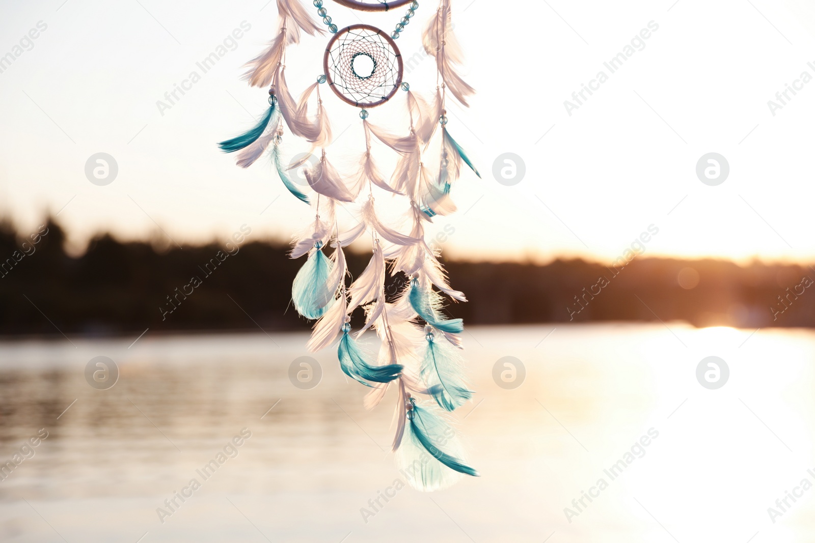 Photo of Beautiful handmade dream catcher near river on sunny day