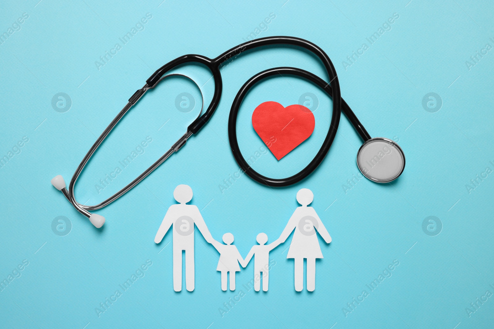 Photo of Paper family figures, red heart and stethoscope on light blue background, flat lay. Insurance concept