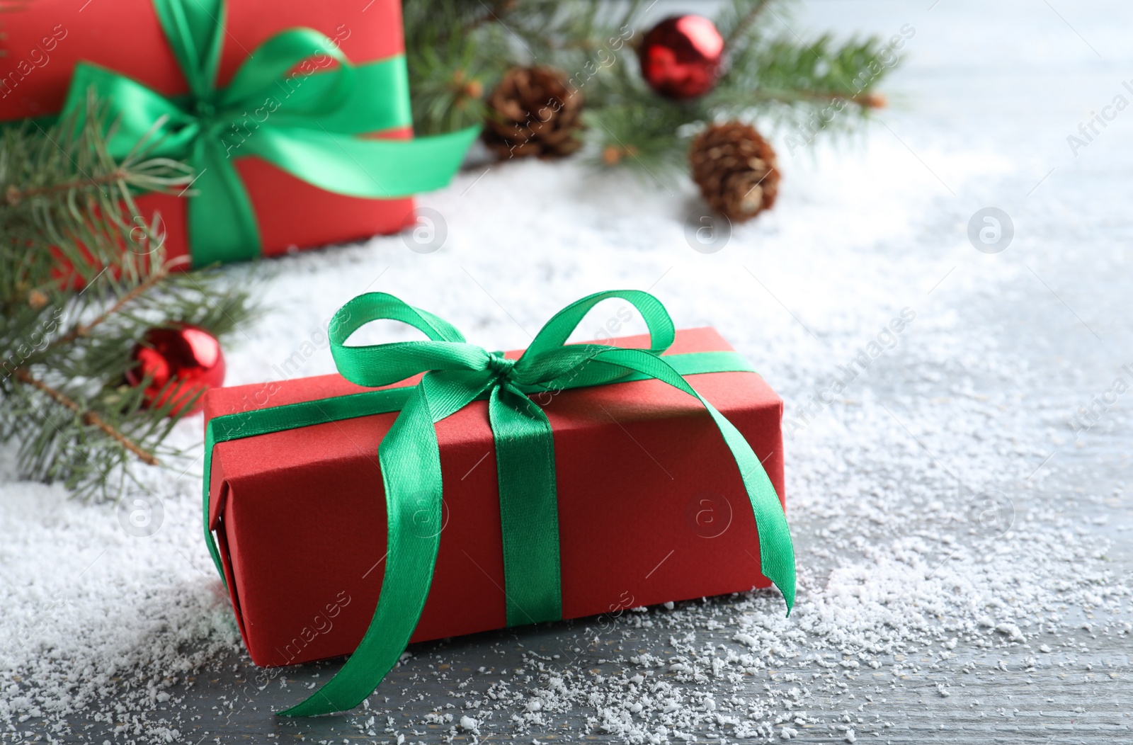 Photo of Gift boxes and Christmas decorations on table with artificial snow