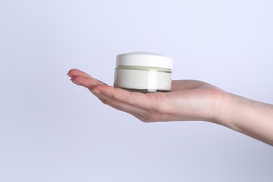 Woman with jar of cream on white background, closeup