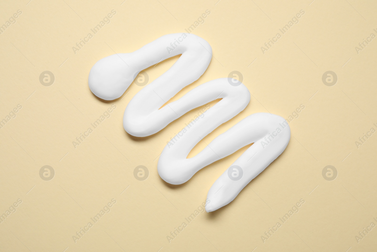 Photo of Sample of shaving foam on beige background, top view