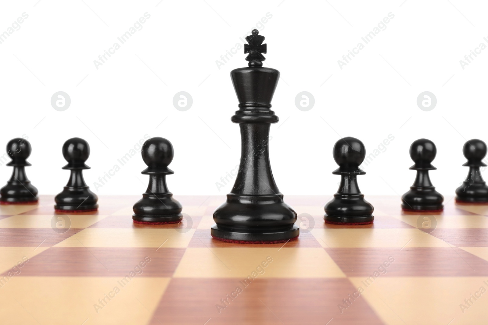 Photo of King among pawns on wooden chess board against white background