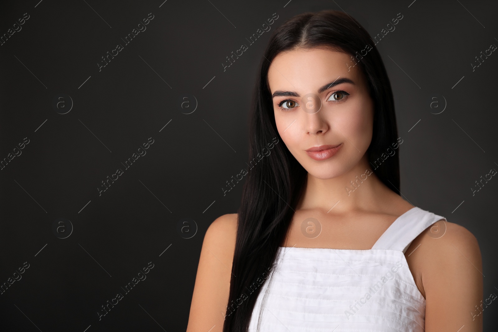 Photo of Portrait of beautiful young woman on black background. Space for text