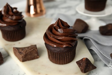 Delicious chocolate cupcake with cream on white marble table