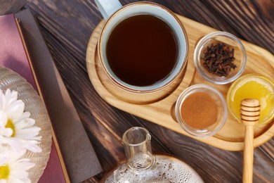 Tray with delicious tea and ingredients on wooden table, flat lay