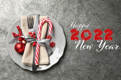 Image of Happy New 2022 Year! Beautiful table setting on grey background, top view 