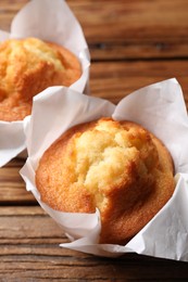 Photo of Delicious sweet muffins on wooden table, closeup