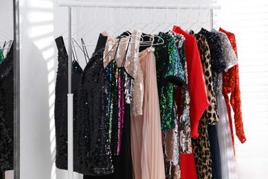 Photo of Different stylish women's clothes on rack indoors
