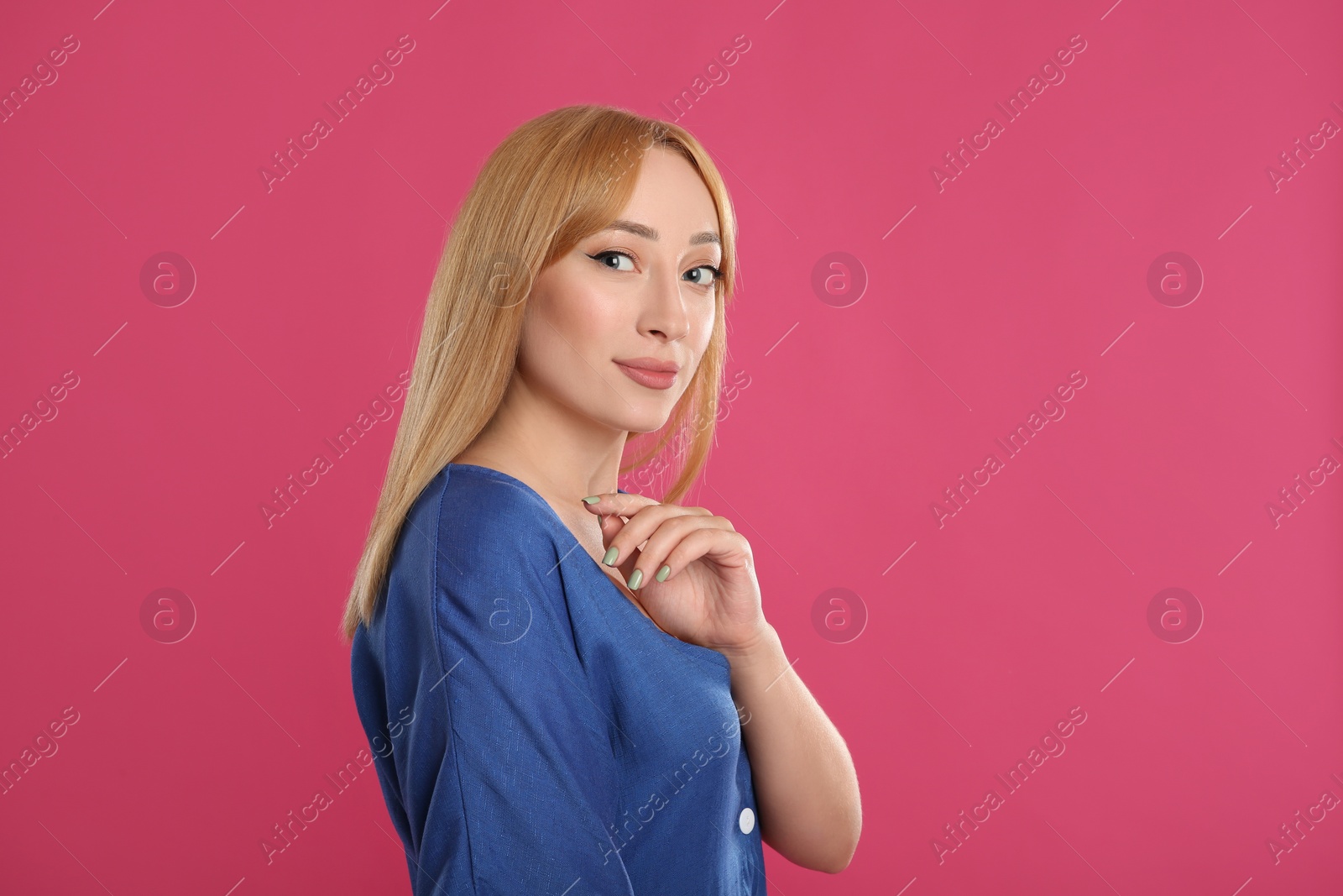 Photo of Beautiful young woman with blonde hair on pink background