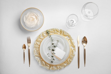 Elegant table setting on light background, top view