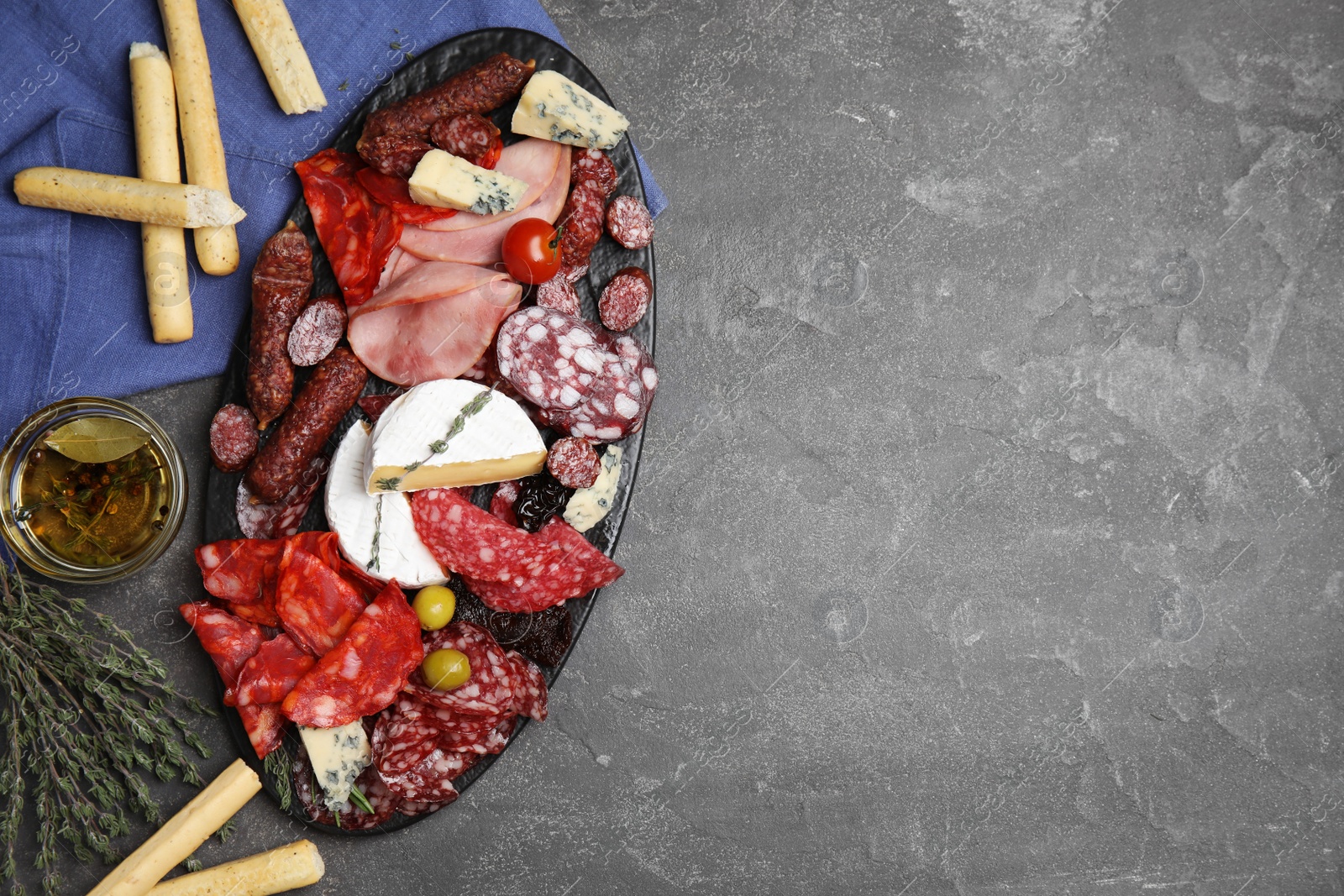 Photo of Tasty ham with other delicacies served on grey table, flat lay. Space for text