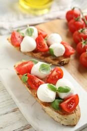 Delicious sandwiches with mozzarella, fresh tomatoes and basil on board