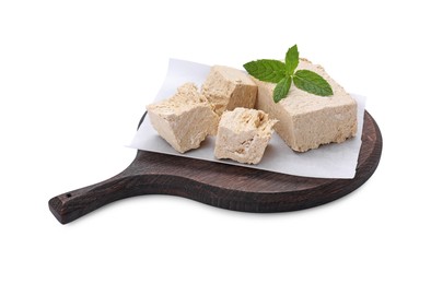 Photo of Board with pieces of tasty halva and mint isolated on white