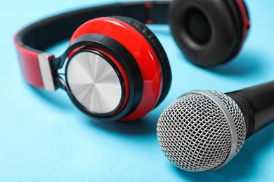 Photo of Stylish headphones and microphone on color background, closeup