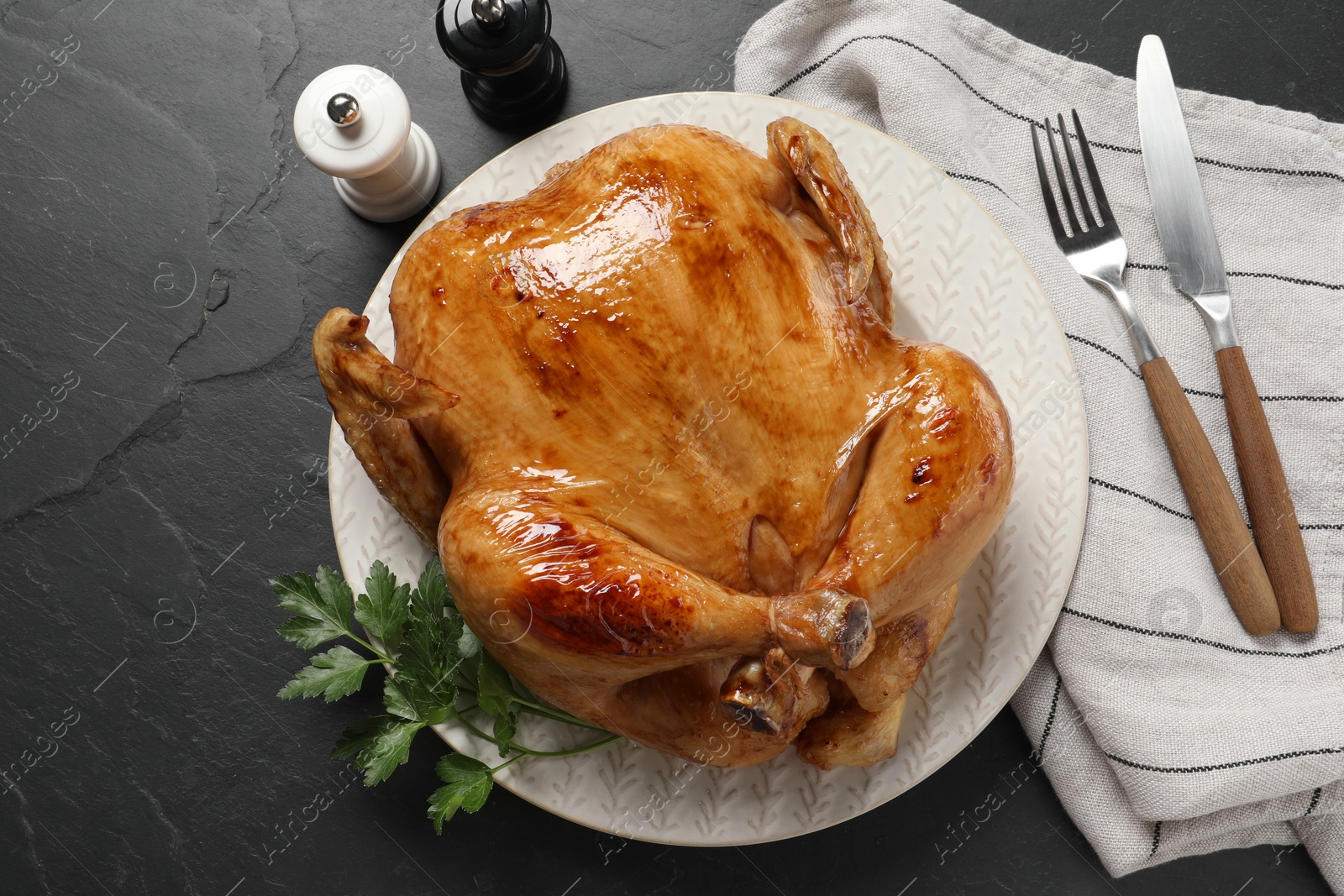 Photo of Tasty roasted chicken served on grey textured table, flat lay