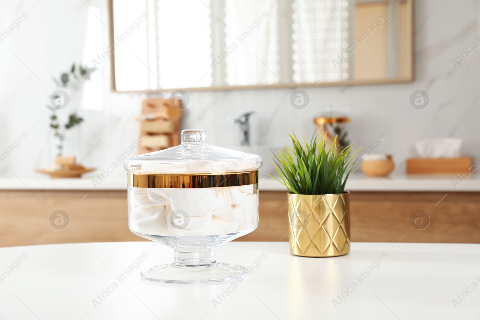 Photo of Jar with cotton pads on table in bathroom