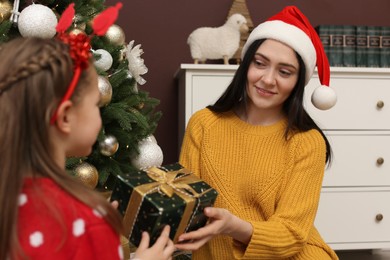 Photo of Mother and daughter with gift box at home. Christmas celebration