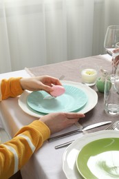 Photo of Woman setting table for festive Easter dinner at home, closeup