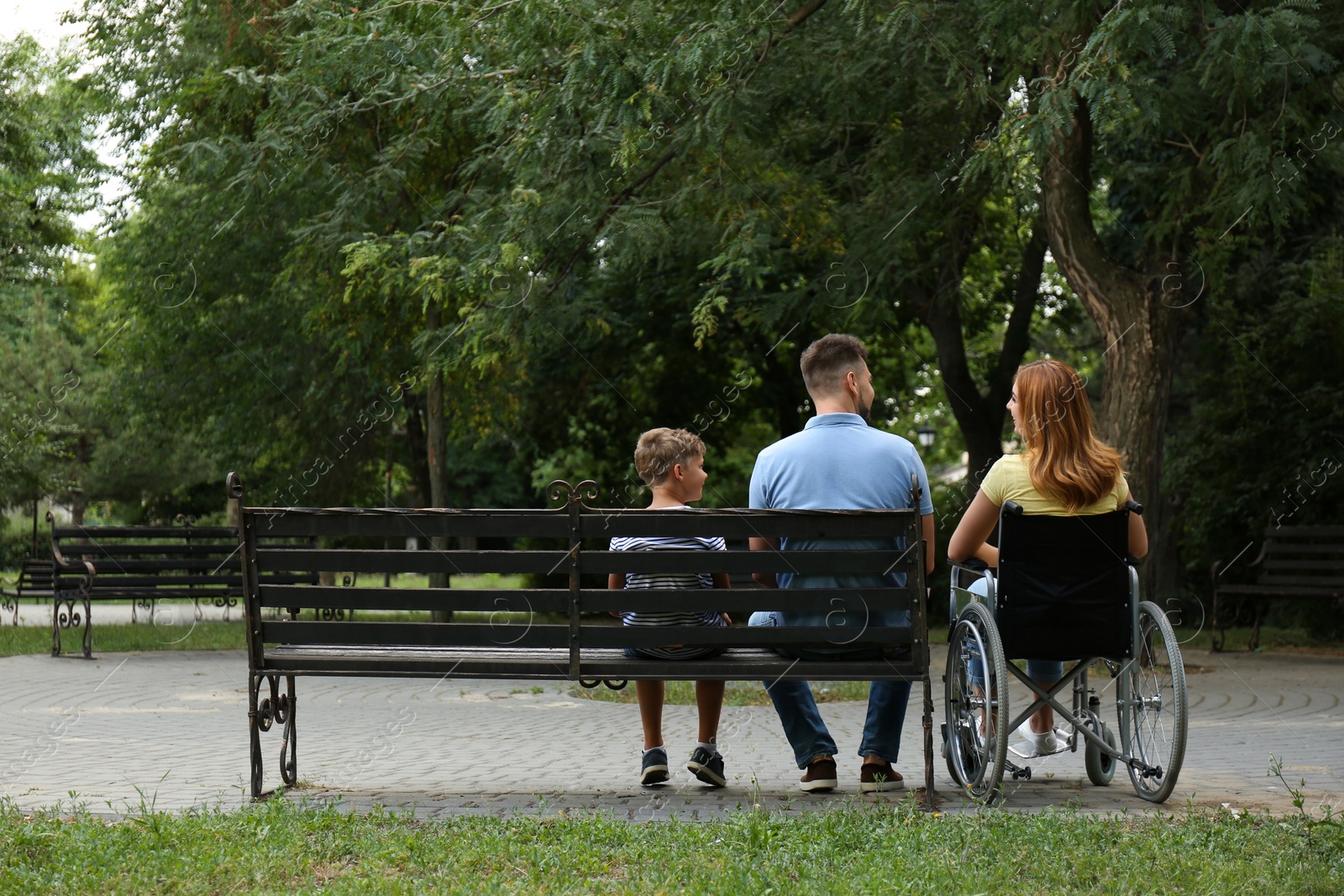 Photo of Woman in wheelchair with her family at park