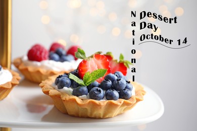 National Dessert Day, October 14. Tasty tartlets with different fresh berries on cake stand