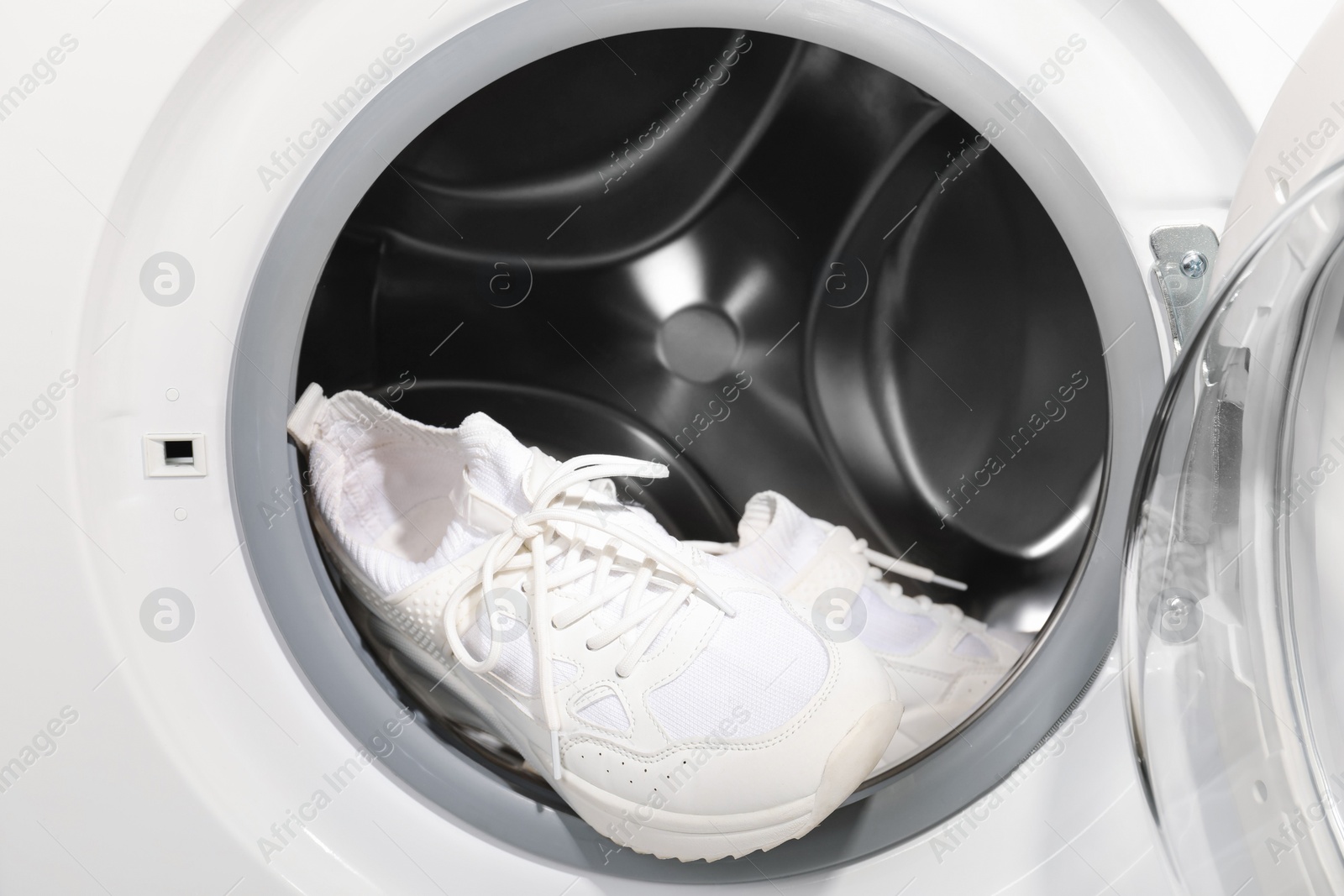 Photo of Stylish clean sneakers inside modern washing machine