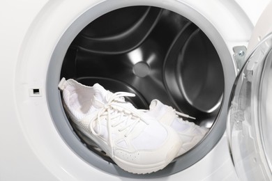 Stylish clean sneakers inside modern washing machine