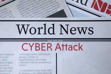 Top view of newspapers with headlines CYBER ATTACK as background, closeup