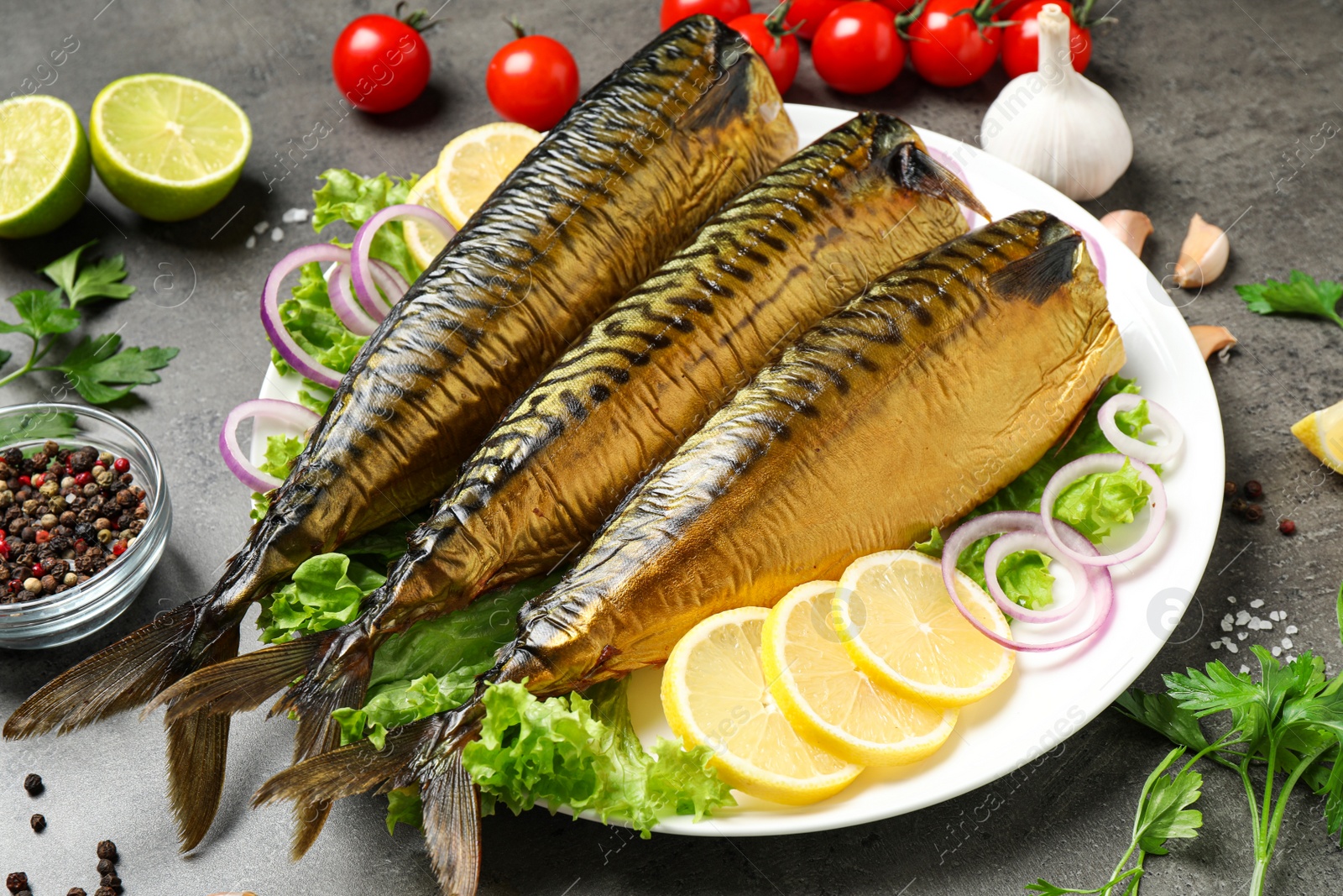 Photo of Tasty smoked fish served on grey table