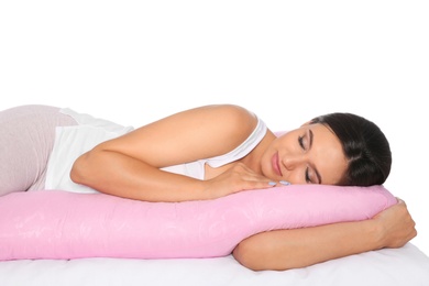 Photo of Beautiful pregnant woman sleeping with maternity pillow on bed against white background