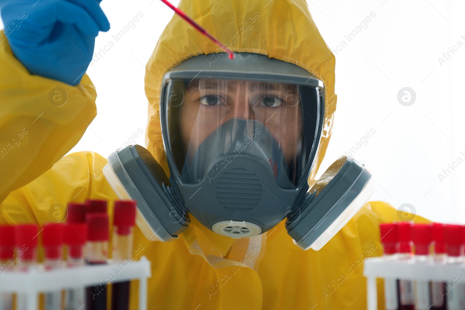 Photo of Scientist in chemical protective suit dripping blood on white background. Virus research