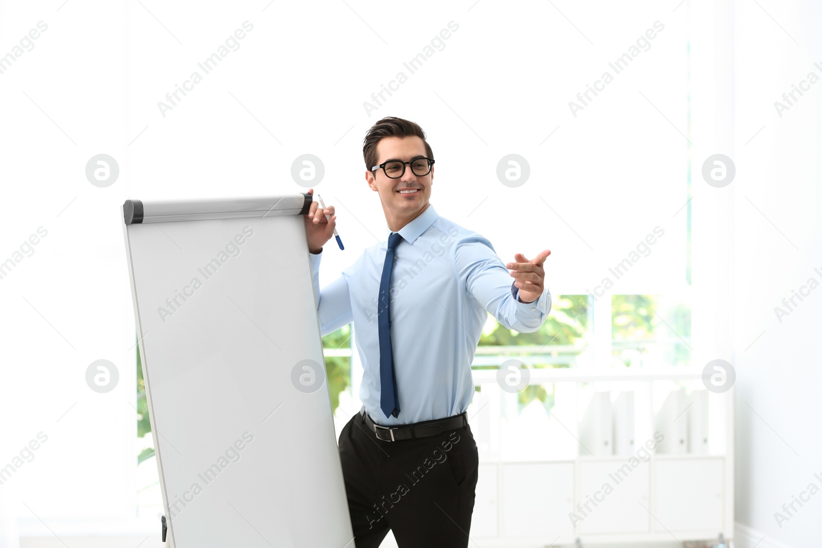 Photo of Professional business trainer near flip chart in office