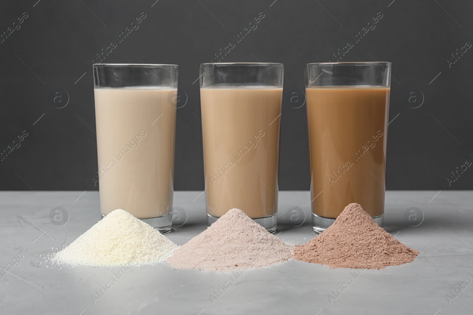 Photo of Glasses with protein shakes and powders on table