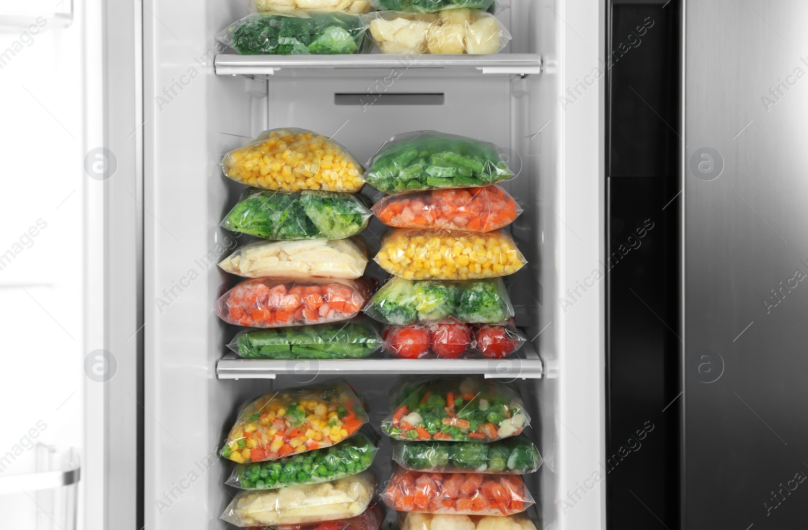 Photo of Plastic bags with different frozen vegetables in refrigerator