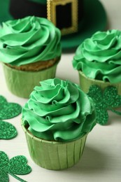 St. Patrick's day party. Tasty cupcakes with green cream on white table, closeup