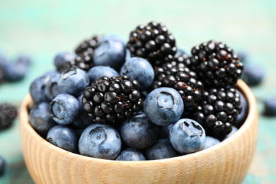 Blueberries and blackberries wooden in bowl, closeup