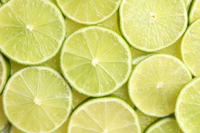 Fresh juicy lime slices as background, top view