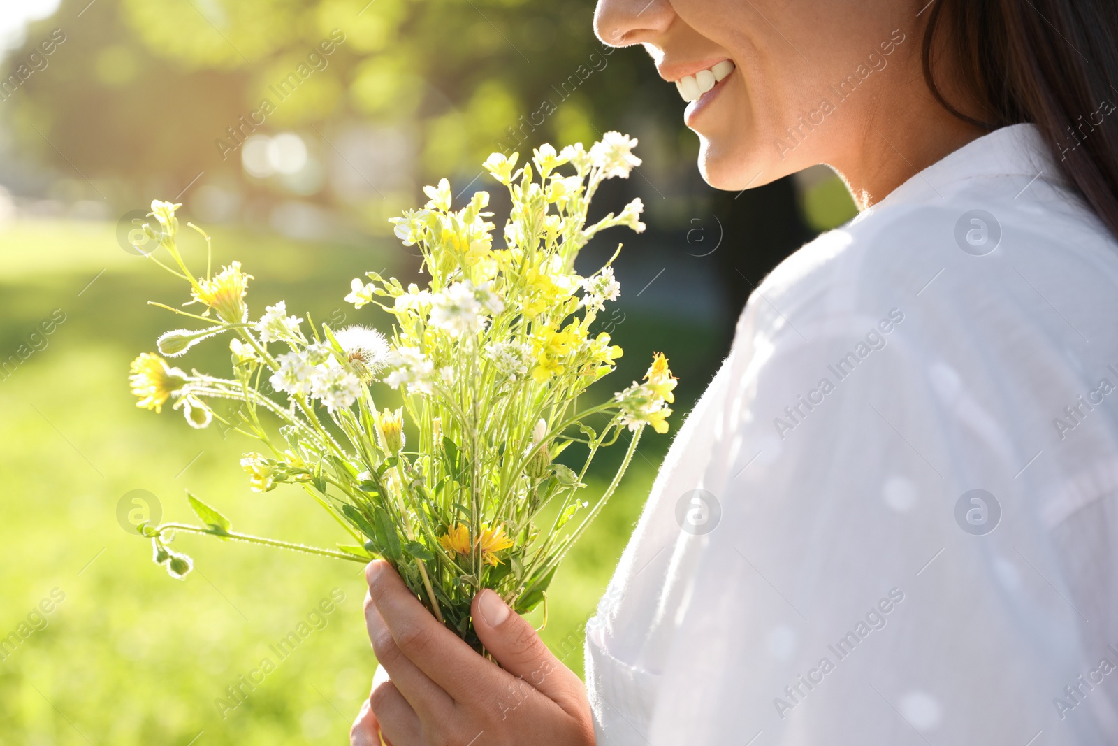 Photo of Young woman with beautiful bouquet outdoors on sunny day, closeup