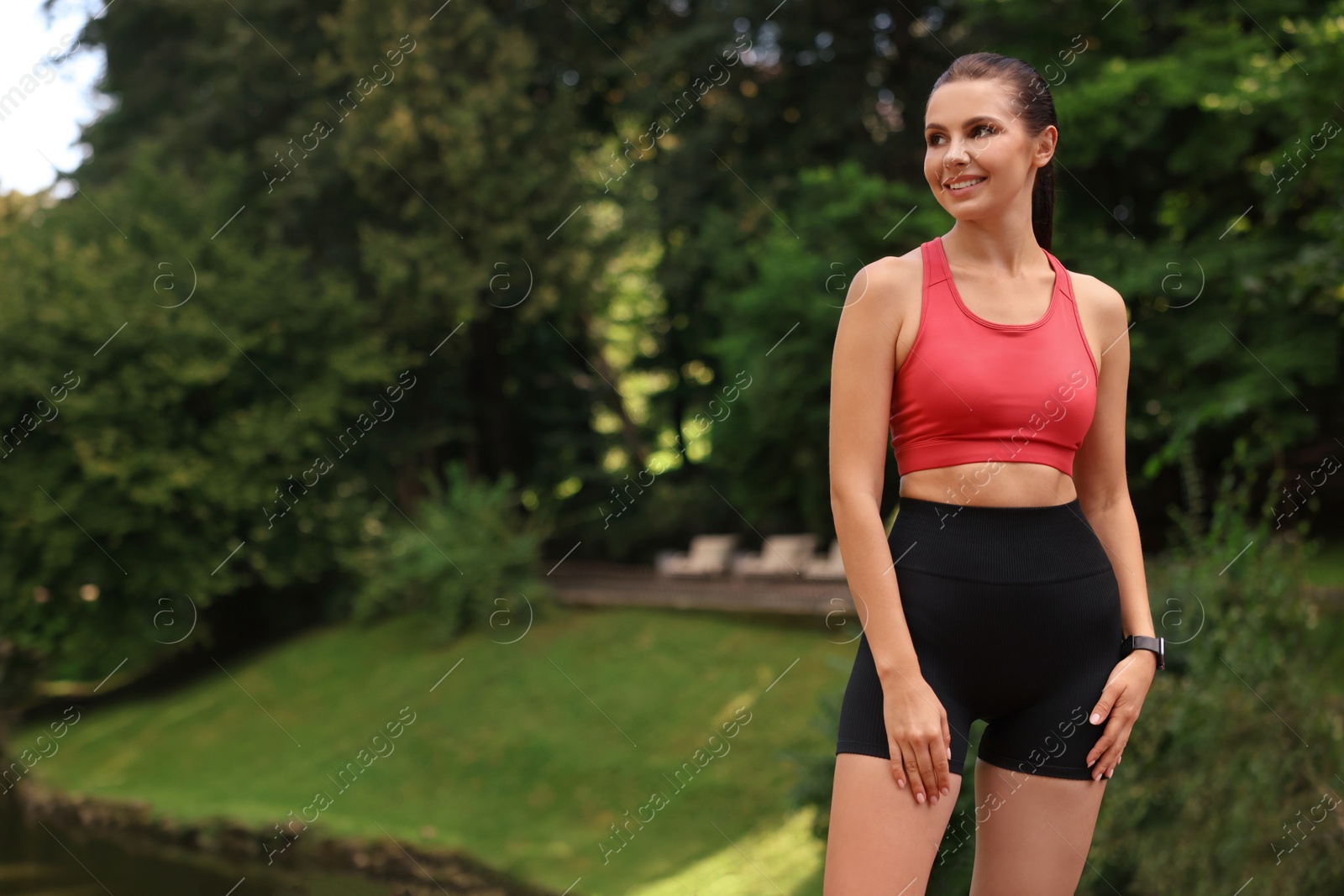 Photo of Smiling woman wearing sportswear in park. Space for text