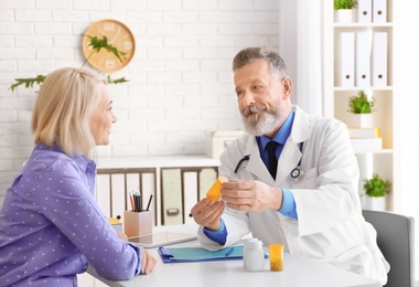 Photo of Mature doctor consulting patient in clinic