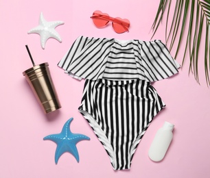 Flat lay composition with women's swimsuit on pink background