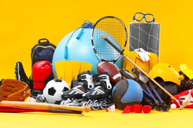 Many different sports equipment on yellow background