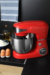 Photo of Modern stand mixer and ingredients on countertop in kitchen. Home appliance