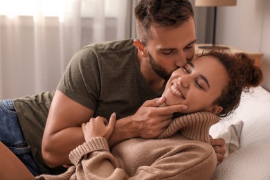 Photo of Lovely couple enjoying each other on bed at home