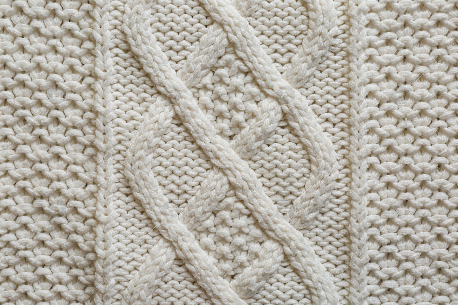 Photo of White knitted fabric with beautiful pattern as background, top view