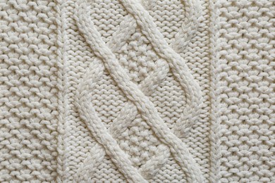 Photo of White knitted fabric with beautiful pattern as background, top view