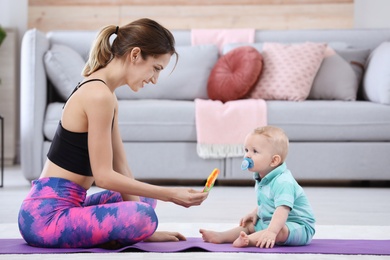 Young sportive woman doing exercise with her son at home. Fitness training