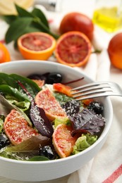 Photo of Bowl of delicious sicilian orange salad on table, closeup